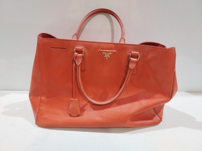 1 X ORANGE COLOURED LEATHER LIKE HAND BAG ( PRADA BRANDED - NO SERIAL NUMBER FOUND )