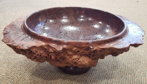 BERT HEIKENS TURNED RED WOOD LARGE AND HEAVY CIRCULAR BOWL WITH NATURAL SURROUND RAISED ON A SMALL PAD FOOT MAX 53CM WIDE, 8.25CM HIGH