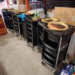 7 X REDKEN 5TH AVENUE NYC SALON TROLLEYS IN BLACK WITH ACCESSORIES HAIR DRYER , BARBERS CLIPPERS , GOLD COLOURED MIRROR TRAYS , HAIR BRUSHES , LUXURY FAKE EYELASHES ETC