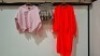 50 X MIXED CLOTHING LOT CONTAINING RISING JUMPER IN PINK IN SIZE M/L , FASHION LONG BOTTOMS IN BLACK IN UNKNOWN SIZE , MINI DRESS IN BROWN/BLACK AND WHITE IN SIZE S ETC IN ONE TUB (NOTE - CLOTHES HAVE A MUSTY ODOUR - TUBS NOT INCLUDED)