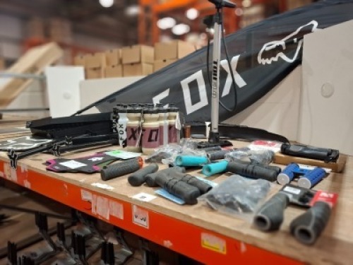 50 X MIXED LOT CONTAINING TRUFLO MAXTRAX 4 FLOOR PUMP , FOX WATER BOTTLES , FOX MUD GUARDSS , FOX BRANDED WALL HANGERS , FOX RACING BANNER , VARIOUS HANDLEBR GRIPS ETC ON 3/4 OF A BAY