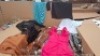 400 + BRAND NEW MIXED CLOTHING LOT CONTAINING MINI BLUE DRESS IN SIZE 14 , ADILYNN FLORAL LADIES PANTS IN MULTI COLOUR IN SIZE SMALL , FASHION LIGHT MINI DRESS IN ORANGE IN SIZE UK 6 , GOLDSK PANTS IN BROWN IN SIZE SMALL ETC IN 1 PALLET BOX