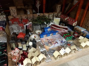 APPROX 100+ PIECE ASSORTED BRAND NEW PREMIER CHRISTMAS LOT CONTAINING WOODEN LIT HOUSE, 50 SHAPE &STAY LIGHTS, CERAMIC CHRISTMAS ORNAMENTS, ACRYLIC LED PRESENTS, SANTA BELT TREE SKIRTS, LARGE WOODEN HOUSE ADVENT CALENDAR, GLASS CANDLE HOLDERS, LANTERNS, V