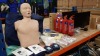 MISC FIRST AID LOT COMPRISING 4 X PRESTIAN ADULT RESUSCITATION MANIKINS (TRADE £150 EACH), 2 X PRESTIAN AED TRAINERS (TRADE £200 EACH), VARIOUS BANDAGES & WIPES PLUS 5 X 2KG POWDER FIRE EXTINGUISHERS & A QTY OF NEW MUGS