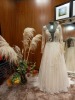 MISC LOT TO INCLUDE - LIFE SIZE MANAKIN WITH (WILLOWBY BY WATTERS) VINTAGE WEDDING DRESS IN A SIZE 8, ALSO A GLASS VASE WITH SUPERFICIAL FLOWERS IN AND AROUND