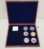 SET OF 6 VARIOUS COMMEMORATIVE COINS, COPPER SILVER PLATED WITH SPOT GOLD, CONTAINED WITHIN A ROSEWOOD COLOURED WOODEN PRESENTATION CASE