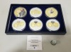 SET OF 6 VARIOUS COMMEMORATIVE COPPER COINS, SILVER PLATED WITH SPOT GOLD EUROPEAN MONARCHS. CONTAINED WITHIN A BLUE PRESENTATION BOX