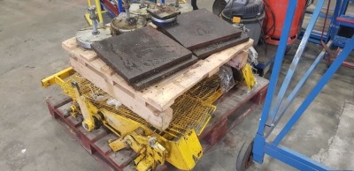 A PALLET CONTAINING A MACHINE GUARD AND VARIOUS ADJUSTABLE MACHINE FEET WITH METAL PLATES