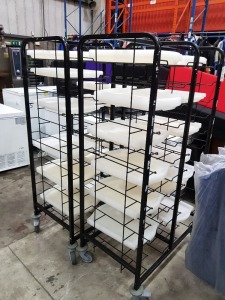 2 X POWDER COATED CLEARING TROLLEY TRAY RACKS - 24 SHELVES ON WHEELS INCLUDES LARGE QUANTITY OF PLASTIC TRAYS