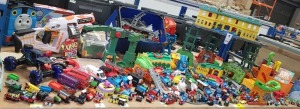 FULL BAY TOY LOT CONTAINING THOMAS AND FRIENDS TRAINS - VARIOUS TRAIN TRACKS - NERF GUN - BOOKS - METAL LONDON BUSES - RACE CARS - STICKERS - VARIOUS TOYS ETC - PREOWNED